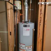 Plumber installing a gas water heater in a Nampa, Idaho residential home