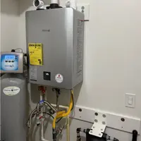 Licensed plumber repairing a tankless water heater in a Nampa, Idaho home